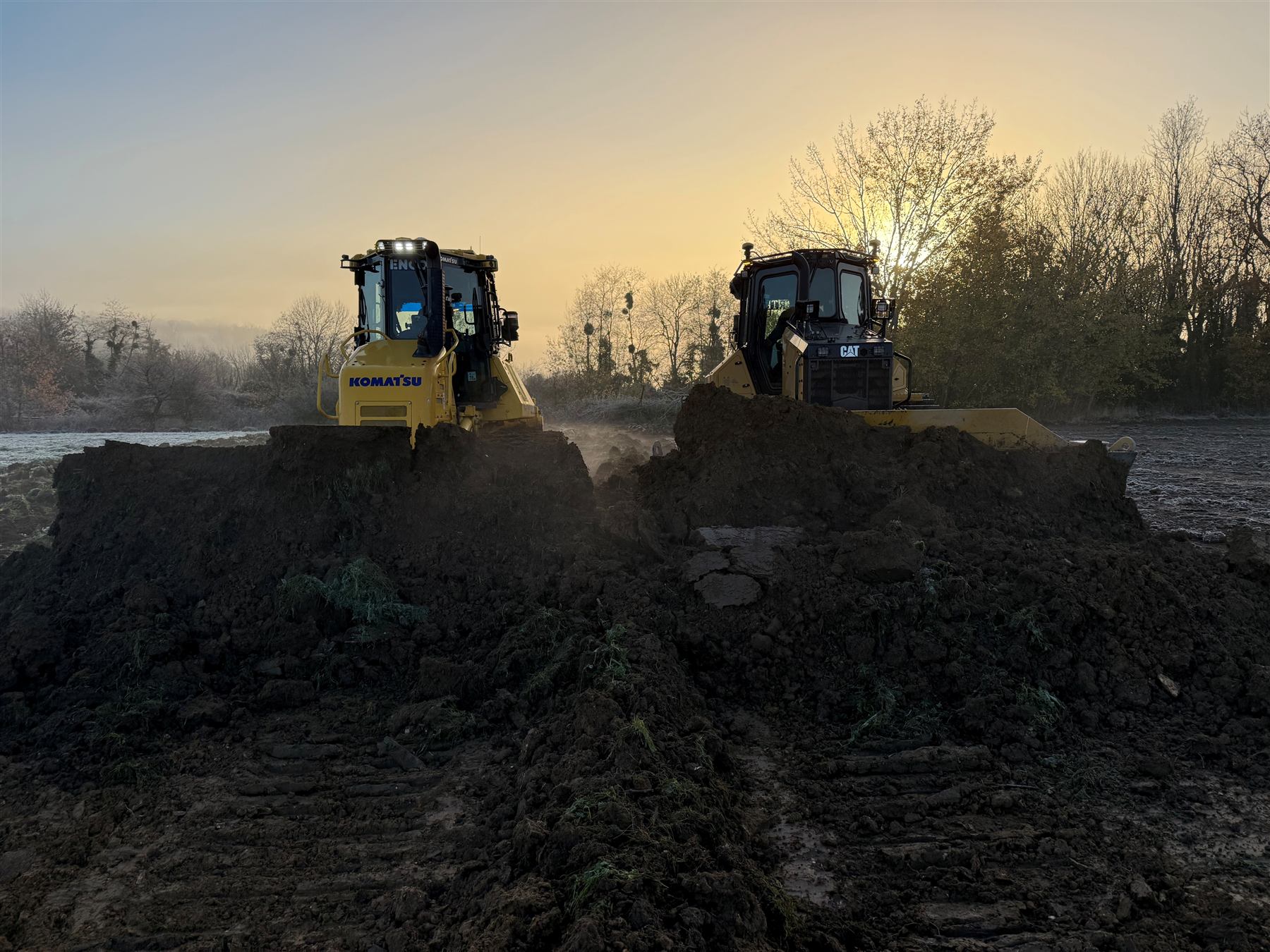 Deux bulldozers au travail à l'aube sur le chantier de Dagny