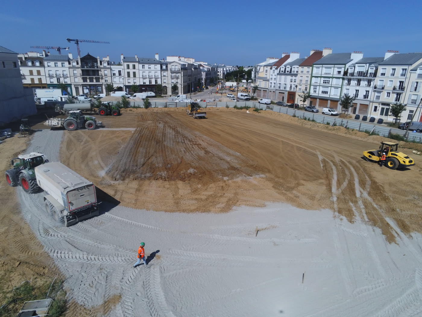 Vue drone de la plateforme et des engins, quartier en arrière-plan