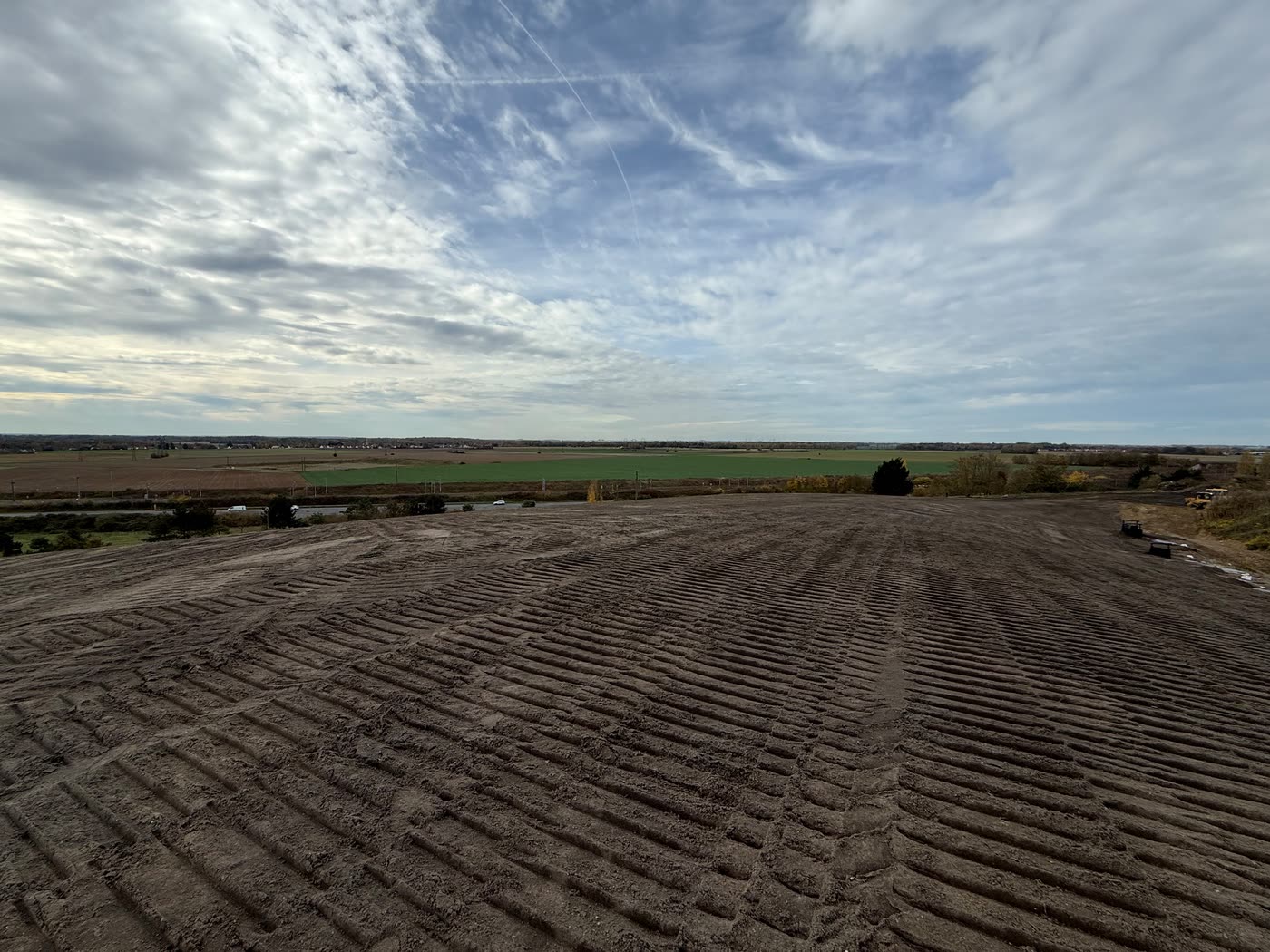 Surface de sable réglée, traces de chenilles, ciel nuageux